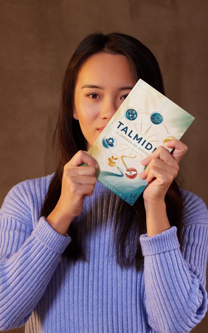 Leitora segurando o livro Talmidim